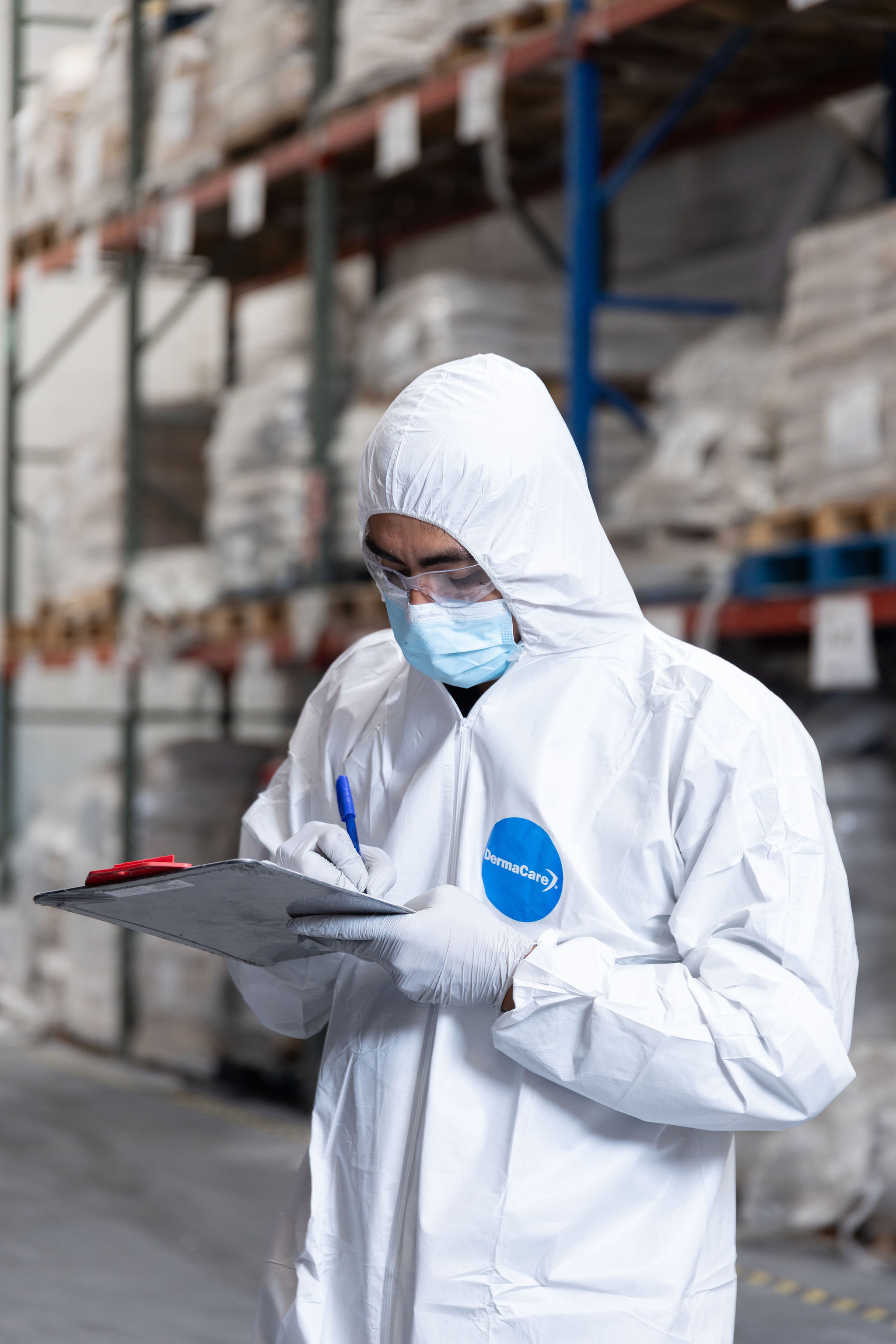 Técnico con tablet revisando producto en almacén.